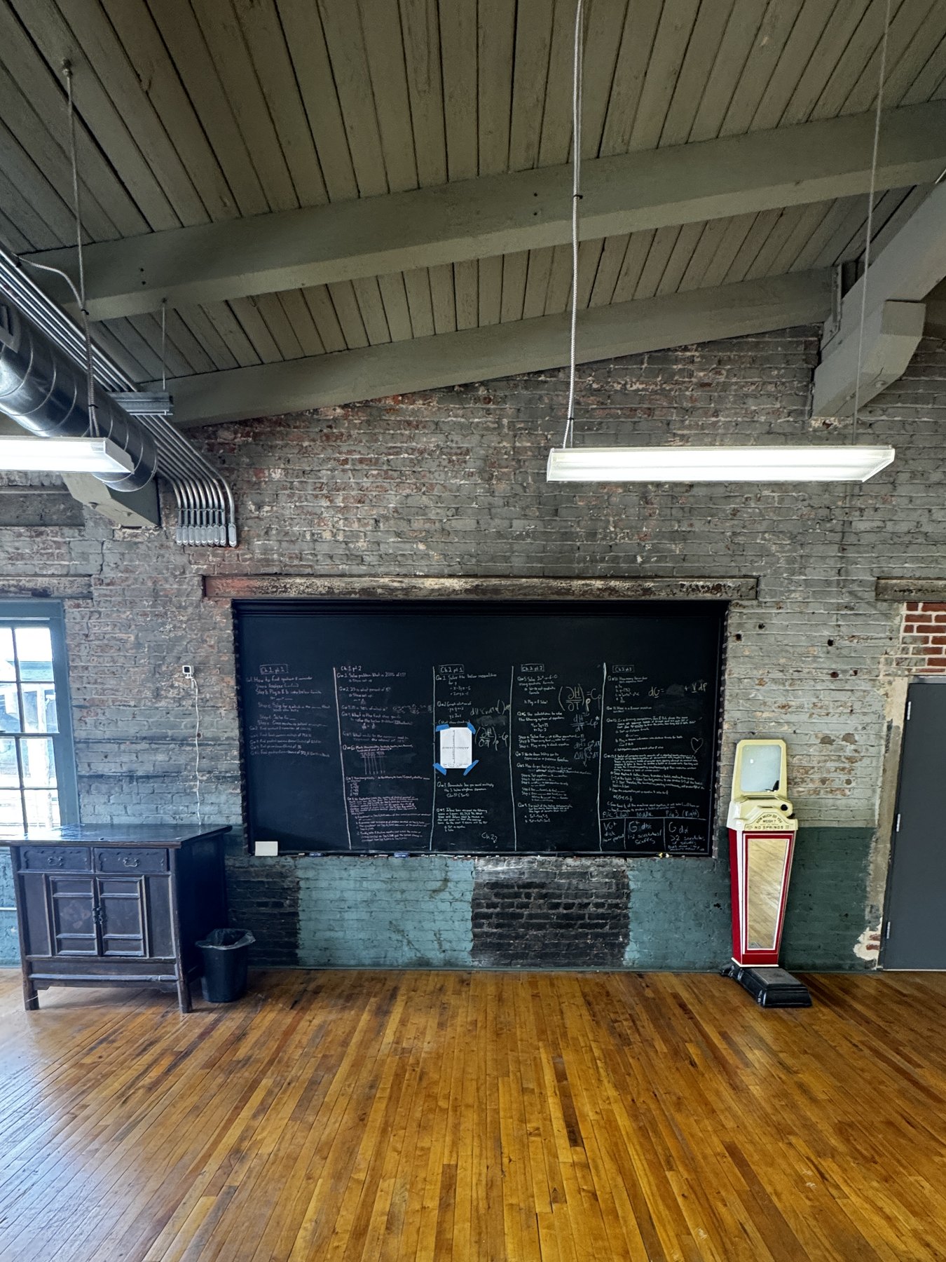 Chalkboard painted directly onto the brick wall beside the room's entrance door.