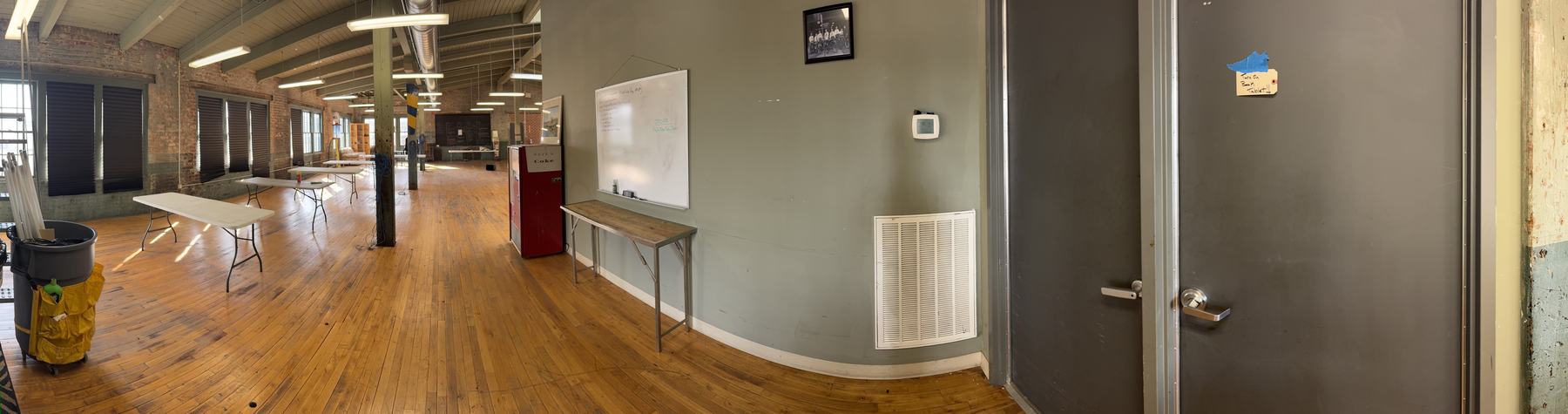Panorama across the room from the window wall to the whiteboard and the entrance doors.